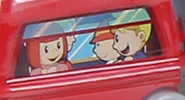 A screencapture of some passengers from the series trailer on a toy train carriage.
