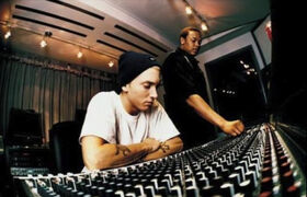 Eminem in a recording booth alongside Dr. Dre.