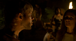 A non-descript survivor glances at the camera while Charlie speaks to a group.
