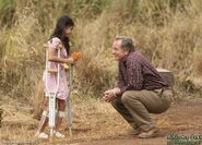 Bernard offrant des fleurs à une petite fille en attendant Rose (S.O.S.)