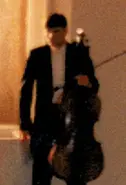 A low quality photo of the cellist.