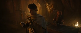 Elrond examines the fragment of mithril given to him by Durin