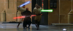 Three men fight with laser swords in a hangar.