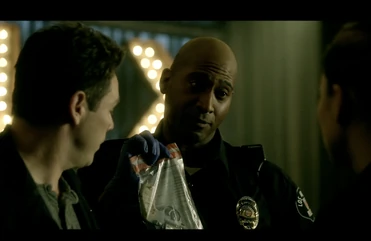 An officer presents  and  with the murder weapon of  - the same revolver  retrieved from evidence lockup for .