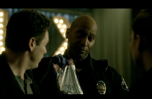 Officer presents the murder weapon to Chloe and Dan