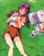 Nanase relaxing on a grassy field next to a magazine featuring Sheryl Nome.