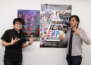 Kawamori standing next to a poster for Shōji Kawamori and Devil May Cry 5, where he helped worked on the designs of the game's weapons.