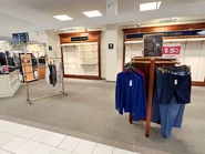 Lower-level Tommy Hilfiger and Ralph Lauren sections, which have been mostly cleared off and is now used for various on-sale items.