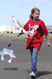 US Navy 110208-N-WP746-189 A student from Pearl Harbor Kai Elementary School retrieves her homemade rocket during her graduation from the STARBASE