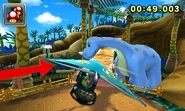 Mario Kart 7 screenshot of Yoshi paragliding toward the dinosaur