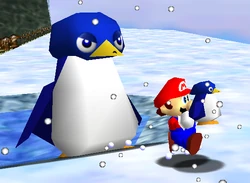 Mario sujetando a Tuxie al lado de la mamá pingüino