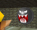 Wario staring at a Fire Chomp in the course.