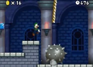 Luigi jumps over a Giant Spiked Ball.