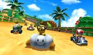 Lakitu racing at Cheep Cheep Lagoon in his Cloud 9 along with many racers in Mario Kart 7.