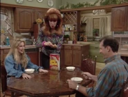 Peggy giving Al and Kelly a single piece of Lucky Charms cereal for their breakfast