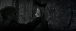 Russell places the explosive on the wall