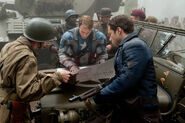 Bucky(front) looking at a map with Steve Rogers and a soldier