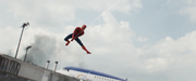 戦場をスイングして横切るスパイダーマン