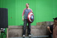 Joss Whedon on set with Captain America's Shield.