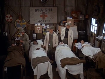 The O Club has been converted into a ward in  (Season 6). Note the Japanese paintings on the walls have been replaced with other decorations. The red and white disc is the emblem of the . Next to it is the emblem of the 69th Fighter Squadron - which never served in Korea. Note one slot machine has been moved to where the jukebox would normally be.