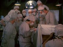 Surgery-the consultant.jpg (37 KB) Surgery scenes are great for identifying people, but only if you have a good eye for eyebrows. Margaret is assisting Trapper. In the foreground, Kellye is the anesthetist.