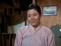 Oksun Kim plays a Korean woman who works in the camp laundry. She will appear again in the last episode to be shot, "As Time Goes By".