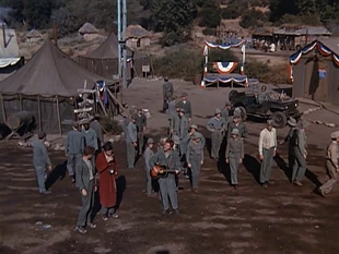 In this closing scene from Big Mac (Season 3) note the stage in the background next to the Officers' Club. Notice Rosie's Bar in the distant background.