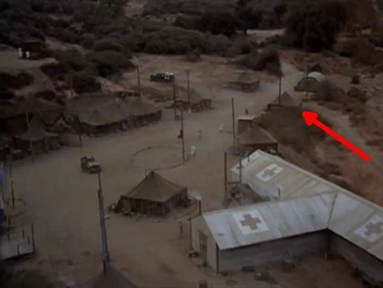 The arrow shows the location of the laundry tent. Next to it is a corrugated iron structure which is the camp latrine, then below it the shower tent and finally the hospital building.