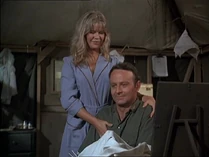 Margaret consoles Frank who is upset that Hawkeye has been appointed Chief Surgeon over him. Note her blue dressing gown with red trim. Lieutenant Carlye Breslin wears it in "The More I See You" (Season 4).
