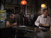 A view of the Officers Club with its early decor. There are two slot machines and a juke box. On the far wall is a Japanese painting.