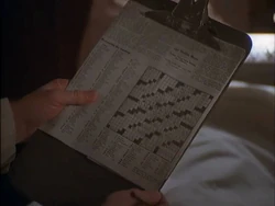 The crossword puzzle in Hawkeye's hands. 1 across is supposed to be "cast" and 1 down "chap" but as can be seen, both of these are 5 letters long.