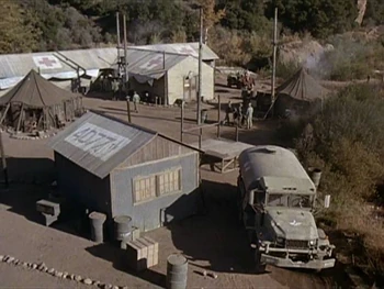 The location of the Officers' Club is clearly shown in this scene from  (Season 7). Note the hospital building with the Swamp in between. To the right of the club building is a wooden stage and further to the right is the Commander's tent.