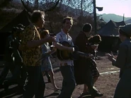 Spalding with the rest of the MASH personnel making a celebratory round of the camp compound after the nurses return. This happy end to the day is appropriately enough shot backlit against the setting evening sun.