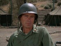 Flagg in his third appearance, in "Officer of the Day". Here he is wearing a lieutenant-colonel rank and the anachronistic modern branch of service insignia of the Military Intelligence Corps. He uses his real name.