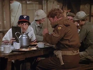The Canadian Corporal Turnbull visits Klinger. For some reason he thinks the 4077th's fruit cocktail is really good. Note Nurse Shari next to Klinger. Klinger is hiding because he owes Hawkeye money.