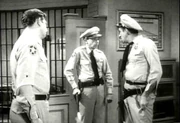 Barney shoots his gun in front of Andy and Gomer.