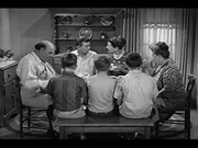 Bruce is sitting to the Right of Opie on the bench.