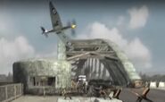 A spitfire flying over the bridge.