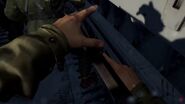 The player reaching for the charging handle