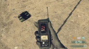 A C4 on the ground and the detonator being held.