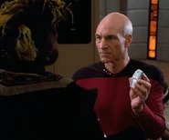 Captain Jean-Luc Picard shows Q a hand phaser that had been set to "stun".