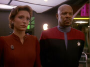 Kira Nerys and Benjamin Sisko listen to Akorem Laan