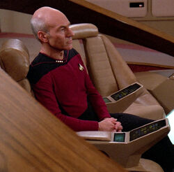 Picard sits in the command chair in 2365, with integrated consoles