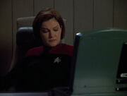 Janeway grimly listens to the computer's alert