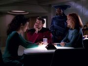 Troi speaking to Riker, Guinan, and Crusher