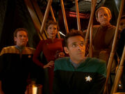 O'Brien, Kira, Bashir, and Odo listen to Kor