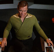 Kirk wearing green wraparound tunic, collar rank