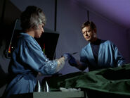 Nurse Chapel and Doctor McCoy wearing gloves during surgery