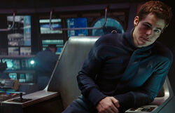 James Kirk in the USS Trainer simulator's command chair, with armrest consoles, in 2258