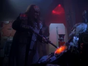 Duras verwendet einen Klingonischen Schmerzstock, um den Tod des K'mpec festzustellen.